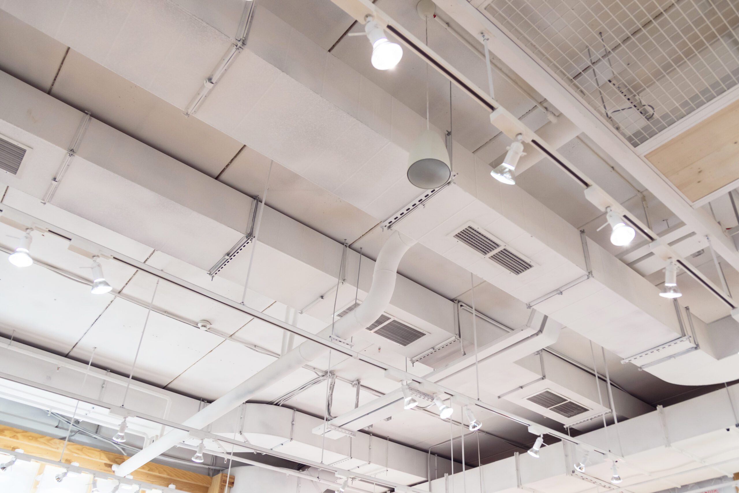 Ventilation ducts system painted in white composition of fire protection under the ceiling